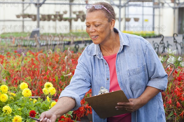 Mixed race woman working in plant nursery