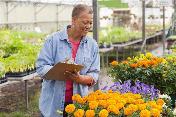 Mixed race woman working in plant nursery