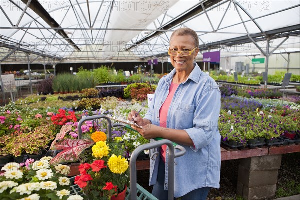 Mixed race woman working in plant nursery