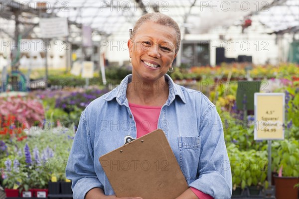 Mixed race woman working in plant nursery