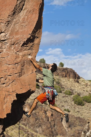 Caucasian man climbing rocks