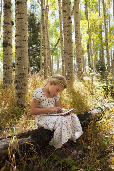 Caucasian girl using digital tablet in woods