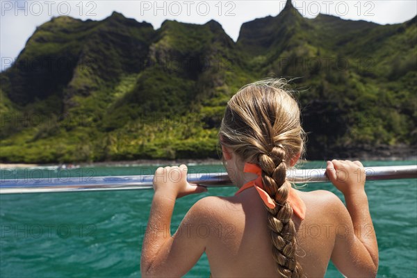 Caucasian girl on boat looking at ocean