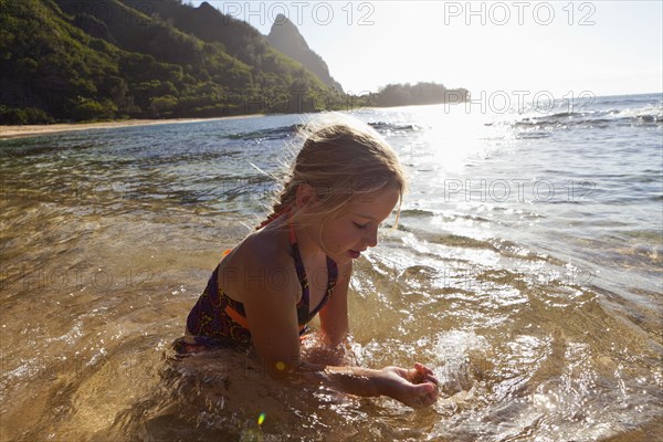 Caucasian girl playing in ocean