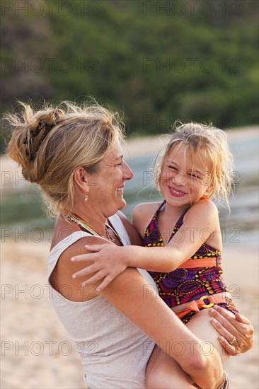 Caucasian mother and daughter enjoying the beach