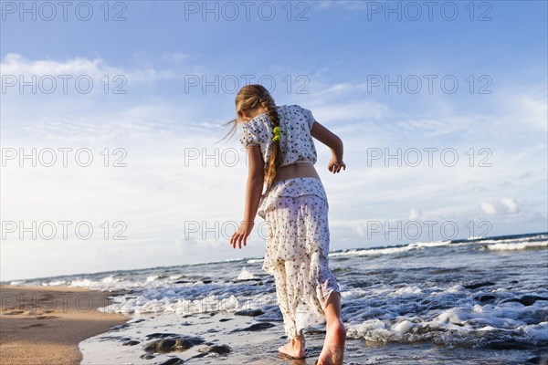 Caucasian girl walking on beach