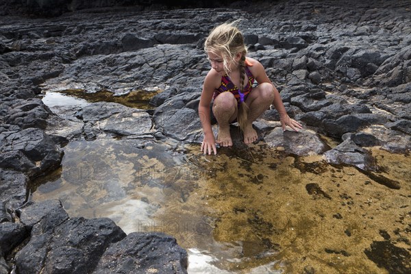 Caucasian girl playing near tide pools