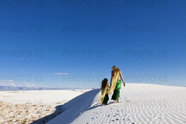 Caucasian mother and daughter walking in desert