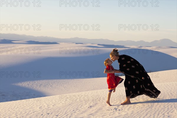 Caucasian mother and daughter kissing in desert