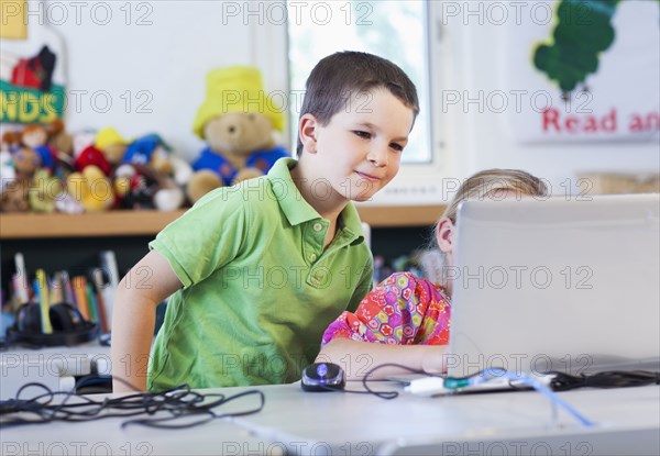 Caucasian students using laptop together