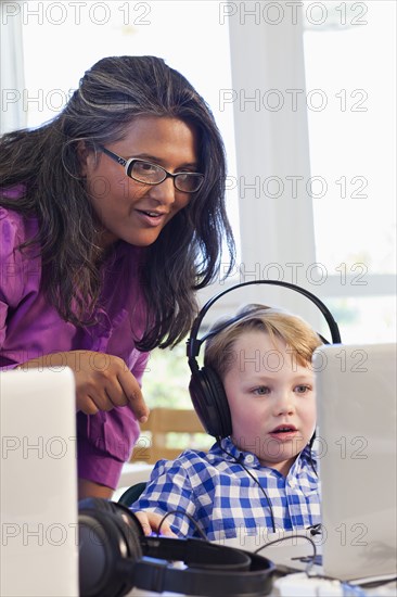 Teacher helping student using laptop