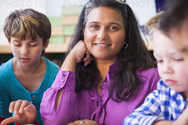 Smiling teacher with students in classroom