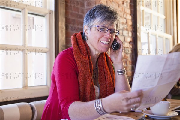 Caucasian businesswoman on phone in cafe
