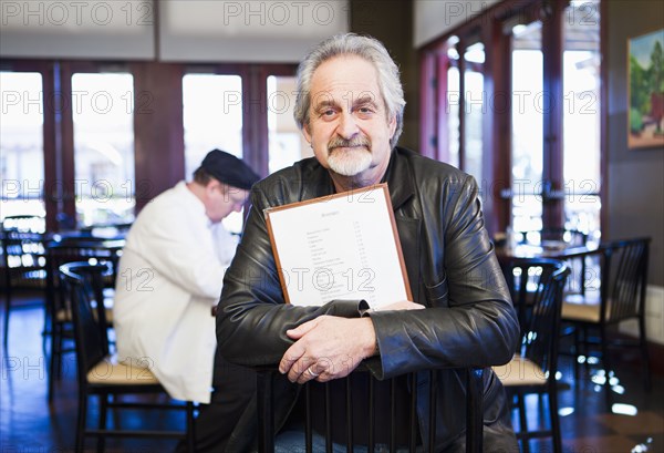 Caucasian man holding menu in restaurant