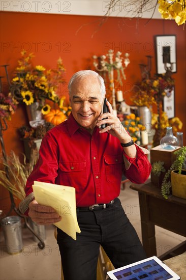 Caucasian florist talking on phone in shop