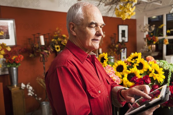 Caucasian florist using tablet computer in shop