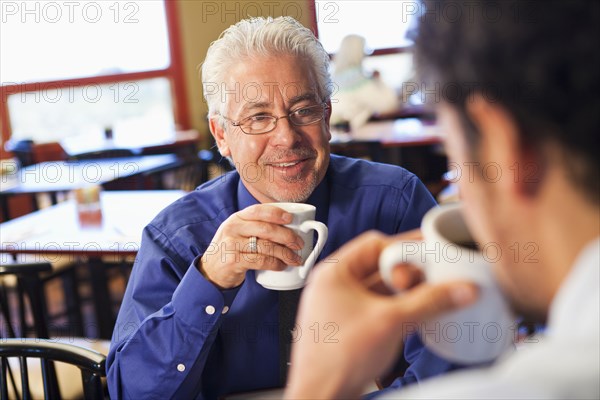 Businessmen having coffee together in cafe