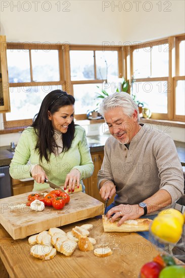 Hispanic couple cooking together in kitchen