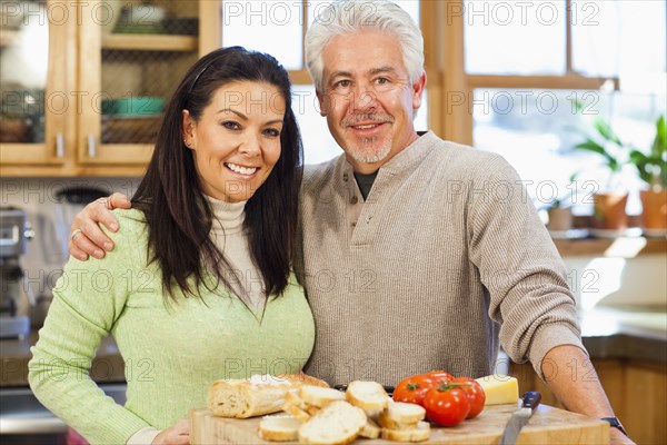 Hispanic couple cooking together in kitchen