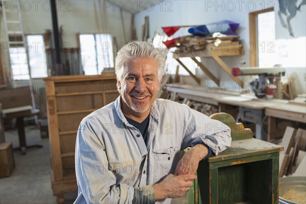 Hispanic craftsman smiling in studio