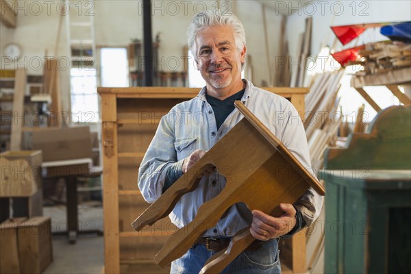 Hispanic craftsman smiling in studio