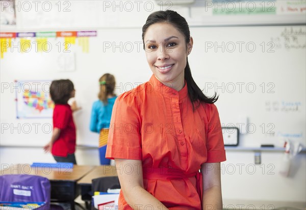 Mixed race teacher smiling in classroom