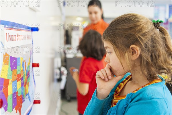 Caucasian student reading map in classroom