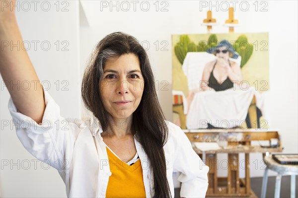 Hispanic artist smiling in studio