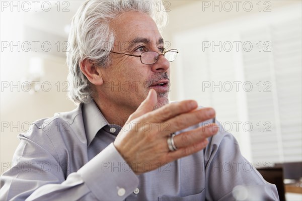 Hispanic businessman gesturing at desk