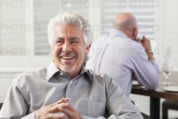 Hispanic businessman laughing in cafe