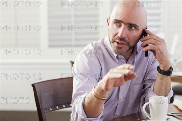 Mixed race businessman talking on cell phone