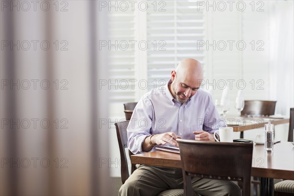Mixed race businessman working in cafe