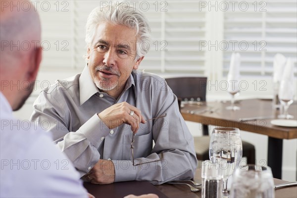 Businessmen talking in cafe