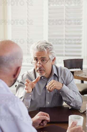 Businessmen talking in cafe
