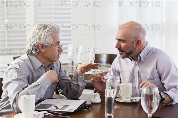 Businessmen talking in cafe