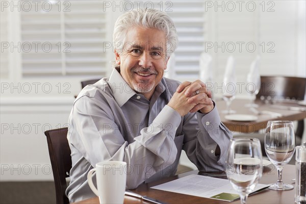 Hispanic businessman smiling in cafe