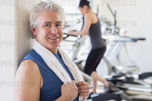 Older Hispanic man smiling in gym