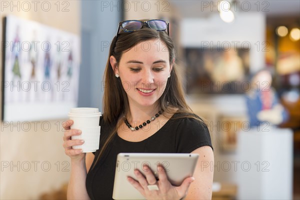 Caucasian woman using tablet computer in art gallery