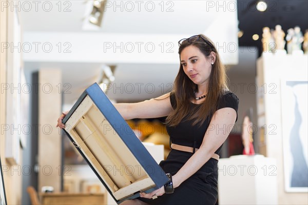 Caucasian woman examining painting in art gallery