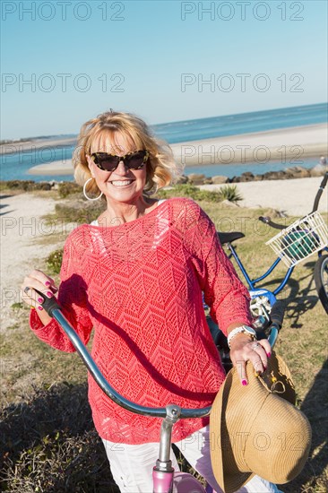 Caucasian woman riding bicycle on beach