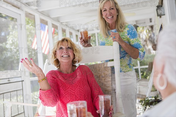 Caucasian women talking on porch