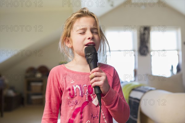 Caucasian girl singing karaoke at home
