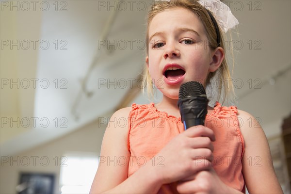 Caucasian girl singing karaoke at home