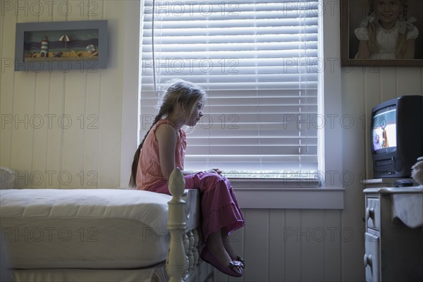 Caucasian girl watching television on bed