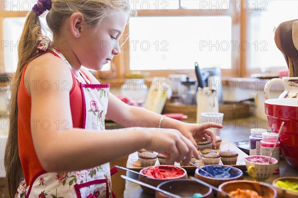 Caucasian girl making cupcakes