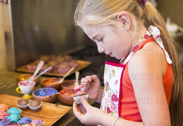 Caucasian girl making cupcakes