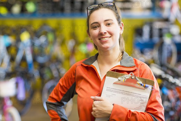 Caucasian woman with clipboard in bicycle shop