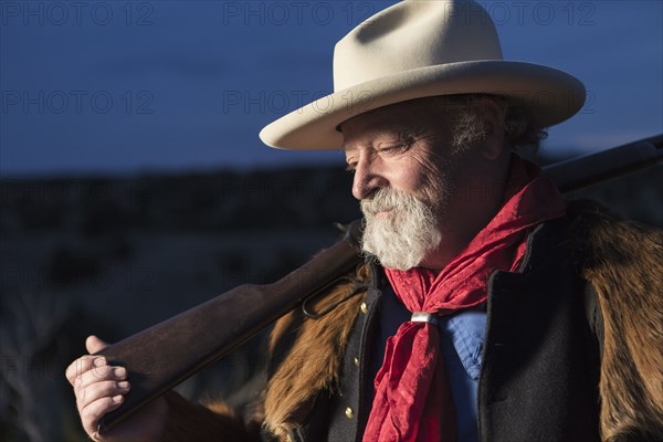 Caucasian man holding gun outdoors