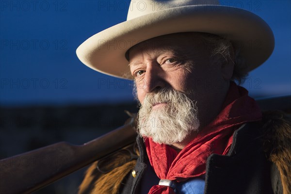 Caucasian man holding gun outdoors