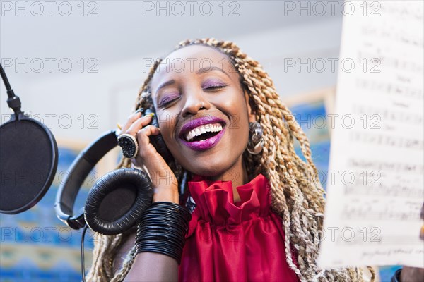 African American singer recording in studio